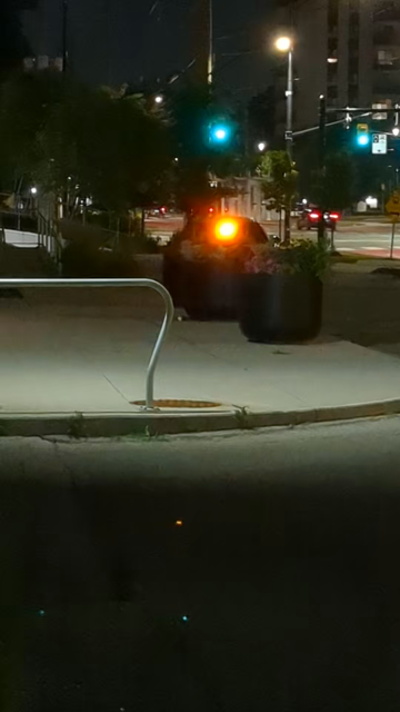 Nighttime shot of bright yellow and white flashing lights mounted near the top of a car's windshield.